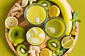 Gesunde Entgiftungsgetränke mit Eiswürfeln, Apfel, Kiwi, Zitrone und Ingwer
