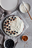 Homemade chocolate cake decorated with white cream and blueberries