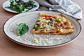 Ein Stück Pizza mit Käse, Pilzen und Schinken