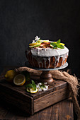 Still life of carefully decorated lime and lemon sponge served on a wooden pedestal