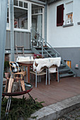 Winterliche Terrasse mit Feuerschale und Schafsfellen