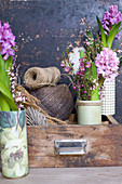 Vases of hyacinths, waxflowers and broom in drawer with balls of twine