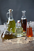 Verschiedene Öle in Glasflaschen und Karaffen