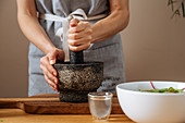 Using mortar and pestle to crush ingredients for sauce