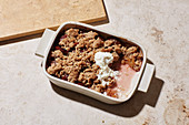 Damson and gingerbread crumble with honey cream