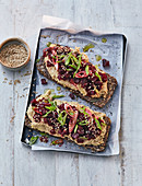 Bread topped with hummus, beetroot tartare and sesame seeds