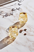 Cocktails with lemon slices and ice cubes garnished with star anise