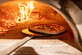 A pizza being baked in a stone oven