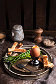 Weichgekochtes Ei mit Toaststreifen und grünem Spargel