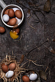 Chicken eggs of white and brown colors, one egg cracked