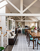 Antique dining table in open-plan interior with exposed roof structure