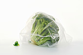 Broccoli in net mesh bag on white background