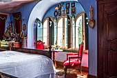Antiques in bedroom with blue-painted walls