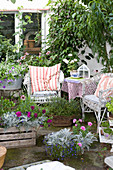 Sommerterrasse mit Korbmöbel, Balkonblumen und Kübelpflanzen