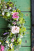 Summer wreath of roses, lady's mantle, chamomile, green apples and tufted vetch