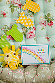 Invitation with rainbow and paper garland onesies