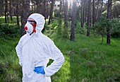 Person in protective suit in forest