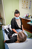 Girl in consultation with a GP wearing a surgery mask