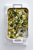 Lasagne with chicory, olives and anchovies in a baking dish