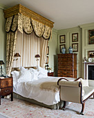 Half-tester bed in classic bedroom with panelled walls