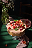 Erdbeer-Käsekuchen mit frischen Beeren und Blumen dekoriert