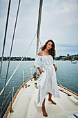 Brünette Frau im Sommerkleid auf einem Boot