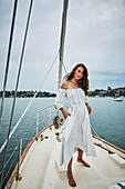 A brunette woman wearing a summer dress on a boat