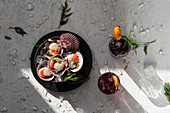 Oriental dish with clams and herbs, cocktails with dried oranges