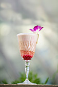 A creamy cocktail with brandy, red Port wine, coconut syrup and grenadine