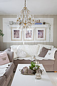 Chandelier above coffee table in shabby-chic living room