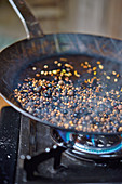 Sausages being made: spices being roasted in a pan