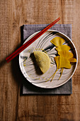 Klebriger Reiskuchen auf Teller dekoriert mit Gingko-Blättern (Asien)