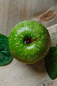Green apple on wooden surface