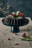 A chocolate Bundt cake with winter decorations on a cake stand