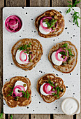 Blinis with sour cream and pickled onions