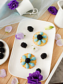 Cheese decorated with blue buttercream and blackberries
