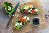 Avocado toast with feta cheese, tomatoes and olives