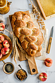Hausgemachtes Challah-Brot (jüdische Küche) serviert mit Honig und Pfirsichen