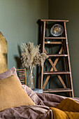 Old ladder in bedroom with green walls