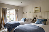 Twin beds against wainscoting in rustic bedroom