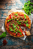 Spelt pizza with salami, rocket and caper apples