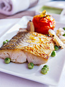 Fried hake with peas and tomato