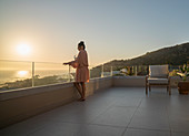 Woman enjoying scenic sunset ocean view on luxury patio