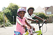 Portrait brother and sister riding bikes