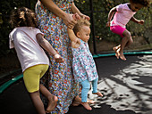 Mother and daughters playing on trampoline