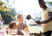 Portrait happy family enjoying barbecue in backyard