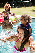 Happy playful family in sunny summer swimming pool
