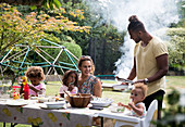 Happy family enjoying summer barbecue at patio table