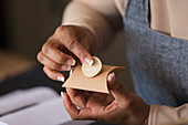 Close up shop owner placing handmade label on box