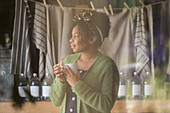 Thoughtful female shop owner drinking coffee